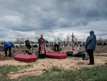 Un sacerdote oficia un funeral por varios muertos tras los ataques de las tropas rusas en la ciudad de Bucha, el  lunes.