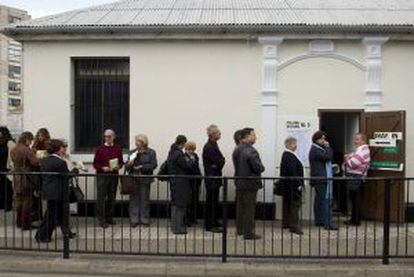 Gibraltareños hacen cola frente a un colegio para votar.