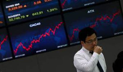 Un hombre en la sede del Korea Exchange Bank junto a unas pantallas informativas que muestran el índice Kospi en Seúl (Corea del Sur). EFE/Archivo