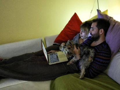 Una pareja ve una película en el ordenador portatil. 