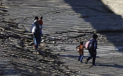 La sombra del muro se proyecta sobre una familia de migrantes mientras entra en EE UU por Imperial Beach (California), el 9 de diciembre.