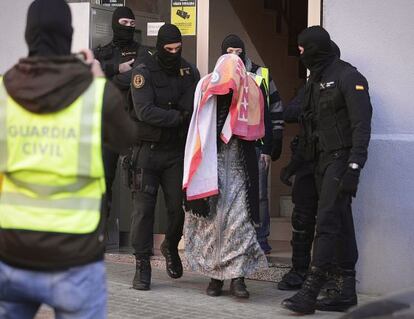 La Guardia Civil saca a uno de los detenidos del inmueble.