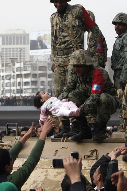 Un soldado subido a un tanque sostiene a un bebé durante una manifestación en El Cairo.