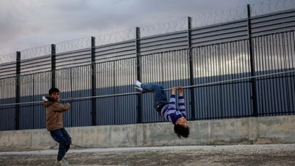 Dos niños palestinos desplazados debido a los ataques israelíes juegan cerca de la valla fronteriza con Egipto, este martes en Rafah (Franja de Gaza).