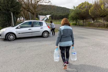 Two residents of Humilladero load jugs of drinking water into their car this Thursday. 