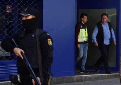 El presidente del Huesca, Agustín Lasaosa, junto a un policía a su salida de las oficinas del club tras ser detenido en mayo de 2018 durante la Operación Oikos.