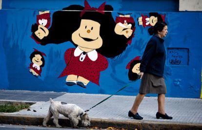 Una mujer pasea ante el mural de Mafalda pintado en la fachada de un hospital infantil en Buenos Aires.