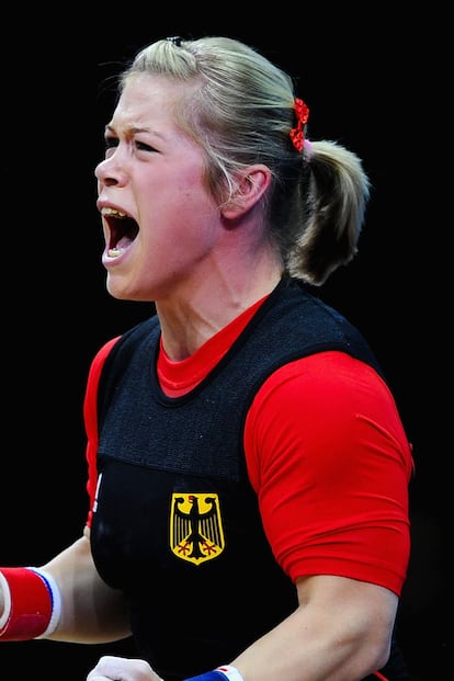 La campeona de halterofilia alemana  Christin Ulrich no se ha limitado a recogerse el pelo para que no la moleste; también ha adornado un lateral con una horquilla con un lacito rojo y se ha hecho un pequeño tupé sobre la frente.