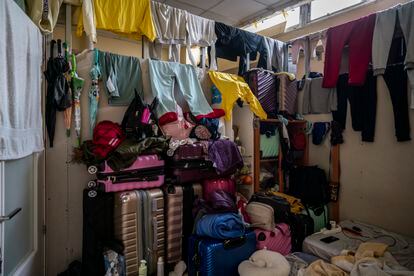 Ropa tendida y maletas en el cuarto de una familia de inmigrantes peruanos en un sótano en Usera. En la habitación de 8,6 metros cuadrados duermen siete personas, entre ellas dos niñas, y les cobran por el espacio asfixiante 700 euros al mes. En total viven otras 13 personas en el mismo bajo.
