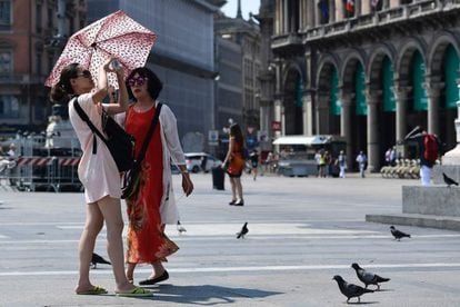 Dos turistas se protegen del sol con una sombrilla en la plaza del Duomo de Milán (Italia), el 22 de junio.