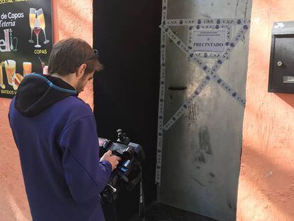 Un cámara de Telemadrid graba la puerta de La Tetería, precintada por la Policía Nacional.