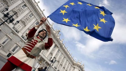 Un miembro del grupo italiano "Sbandieratori di Siena" mientras sostiene una bandera de la Unión Europea frente al Palacio Real en Madrid.