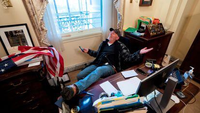 Richard 'Bigo' Barnet, seguidor de Donald Trump, en el escritorio de la presidenta de la Cámara de Representantes, Nancy Pelosi, tras el asalto al Capitolio del 6 de enero de 2021 en Washington (Estados Unidos).