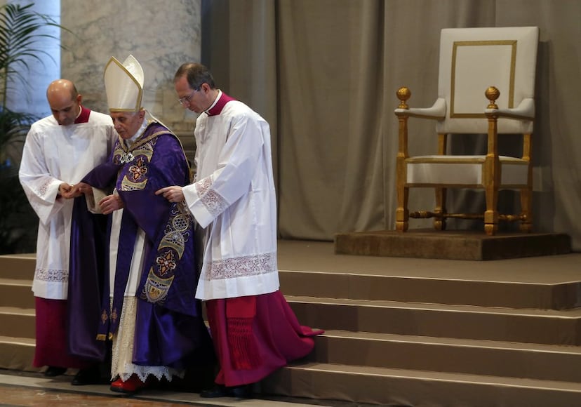 El papa Benedicto XVI es ayudado a bajar las escaleras en la celebración de la misa del Miércoles de Ceniza en el Vaticano, el 13 de febrero de 2013, su último acto litúrgico antes de su renuncia. Sin avisar, en latín, dos días antes, en una reunión en la que iba a informar sobre varias canonizaciones, anunciaba su adiós al papado. "Para gobernar la barca de San Pedro y anunciar el Evangelio es necesario el vigor tanto del cuerpo como del espíritu, vigor que en los últimos meses ha disminuido en mí de tal forma que he de reconocer mi incapacidad para ejercer bien el ministerio que me fue encomendado”.