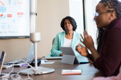 Una mujer ejecutiva dirige una reunión con su equipo de trabajo.