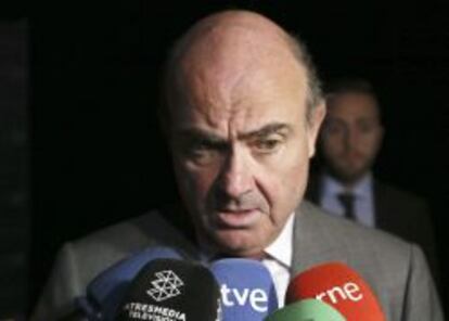 El ministro de Economía y Competitividad, Luis de Guindos, habla con periodistas durante su intervención en una jornada del Banco Interamericano de Desarrollo.