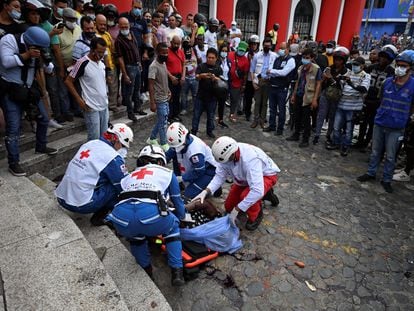 La Cruz Roja colombiana recoge el cadáver del funcionario de la Fiscalía linchado tras disparar contra dos manifestantes.
