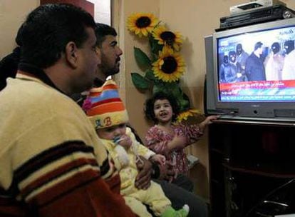 Una familia iraquí contempla en televisión, en su casa de Basora, las imágenes de la ejecución de Sadam Husein, el pasado 30 de diciembre.