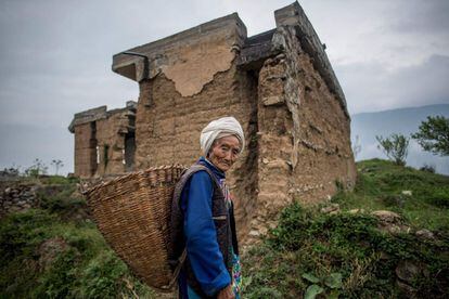 Retrato de una anciana de la minoría Qiang frente a su antigua casa en la aldea de Luobozhai, que fue dañada durante el terremoto de Sichuan en 2008, en el condado de Wenchuan (China).