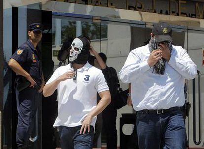 Dos de los acusados, con las caras ocultas, salen de la Audiencia de Madrid el pasado junio.