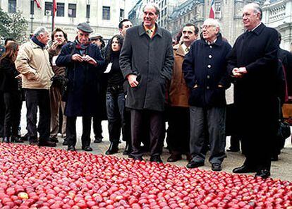 Ricardo Lagos, a la derecha, y el pintor José Balmes, segundo por la derecha, ante el corazón de manzanas rojas instalado frente al Palacio de la Moneda.