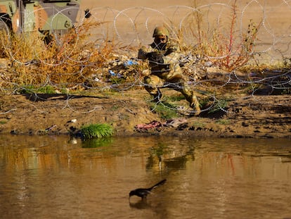 Un miembro de la Guardia Nacional de Texas coloca alambre de púas a orillas del río Bravo, frontera entre Estados Unidos y México.