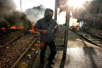 Un manifestante circula ante una barricada que bloquea la línea férrea en la estación asturiana de Villalbona.