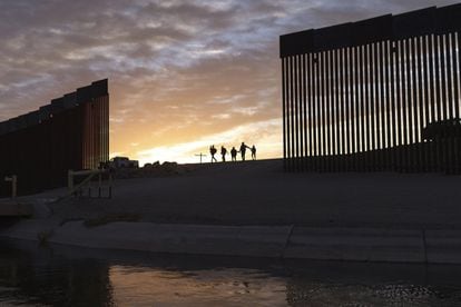 Familias de migrantes cruzan el muro fronterizo entre México y Estados Unidos.