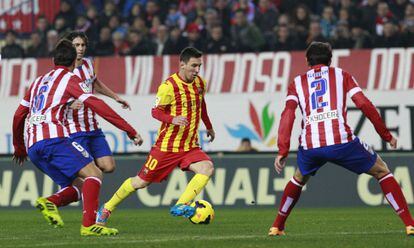 Leo Messi controla el balón ante Koke, Tiago y Godín