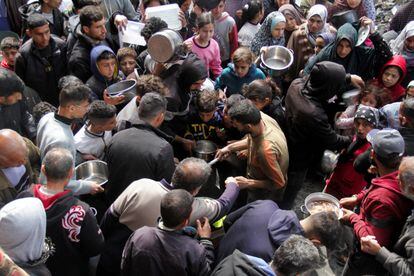 A group of people wait to receive food at a food distribution in Jabalia, northern Gaza.