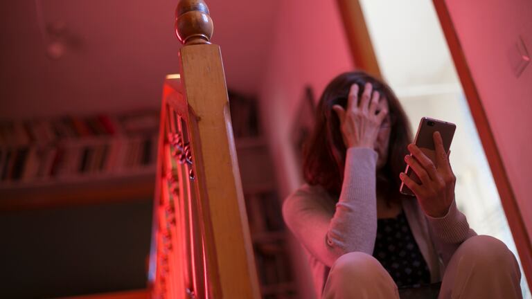 Una mujer consulta el móvil en su casa, durante el periodo de confinamiento.