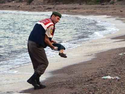 Un policía traslada el cadáver de un niño en una playa de Turquía.