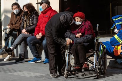 Unas personas mayores toman el sol en la calle, en Shanghai, China. 