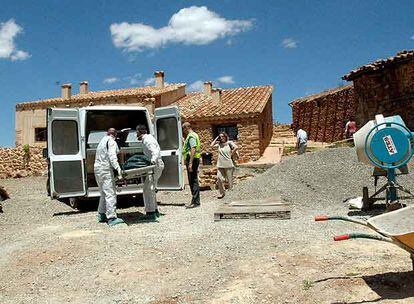 Dos miembros de los servicios funerarios trasladan el cadáver del trabajador fallecido en Teruel.