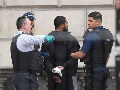 Un joven de algo más de 20 ha sido detenido en Whitehall, en las cercanías del Parlamento británico en Londres, tras un incidente con la policía. En la imagen, el joven arrestado es rodeado por la policía.