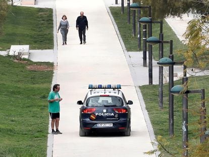 Una patrulla de la Policía Nacional recorre el viejo cauce del Turia , en Valencia, advirtiendo a los ciudadanos sobre la obligación de confinarse en sus casas cumpliendo con las normas del estado de alarma.