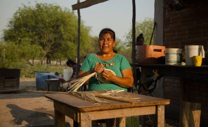 Nelia Miranda, artesana yshyr de 42 años, teje un cesto de hoja de palma en el patio de su casa, en Puerto Diana.