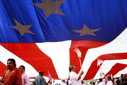 Trabajadores latinos procedentes del Estado de Florida sostienen una bandera estadounidense gigante durante la marcha en Washington.