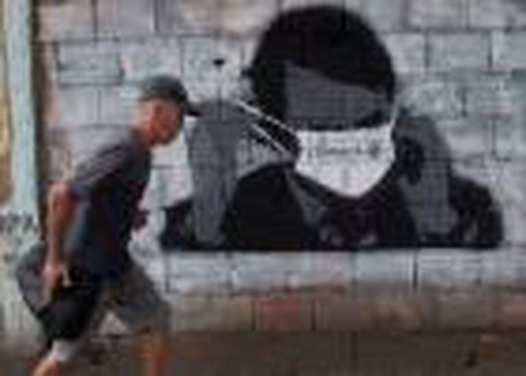 Un ciudadano pasa ante un grafiti del presidente Bolsonaro.