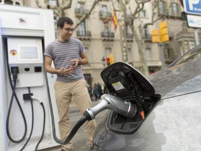 Un conductor enchufa su coche el&eacute;ctrico en un punto de recarga r&aacute;pida ubicado en el paseo de Gr&agrave;cia.