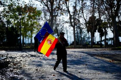 Un hombre portaba una bandera española y otra de la Unión Europea durante el acto organizado por el Partido Popular "en defensa de la Constitución y de la igualdad", este domingo en Madrid. 