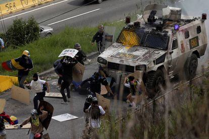 Un vehículo blindado atropella a un grupo de manifestantes durante una protesta contra el Gobierno de Nicolás Maduro, este martes en Caracas.