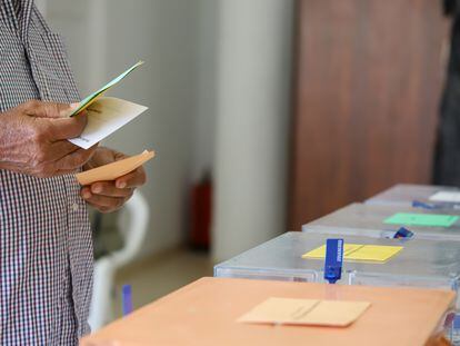 Un hombre sostiene sus papeletas de votación ante las urnas de la mesa en un colegio electoral de la isla de La Palma, el pasado domingo.