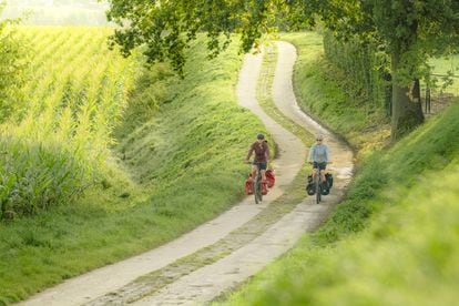 Dos cicloturistas enj una ruta por la región de Flandes, en Bélgica.