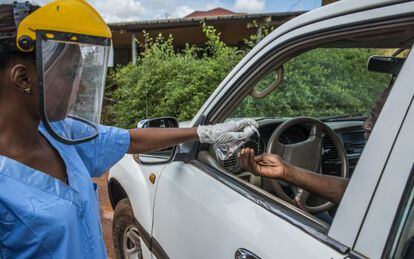 Una treballadora sanitària desinfecta les mans d'un visitant del centre mèdic de Kamsar, a Guinea, el 7 de setembre passat.
