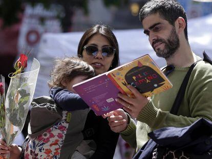 Una familia ojea un libro en un puesto del centro de Barcelona. 