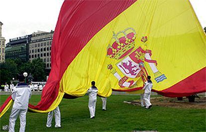 Marineros de la Armada despliegan la bandera en la plaza de Colón, de Madrid. PLANO GENERAL - ESCENA