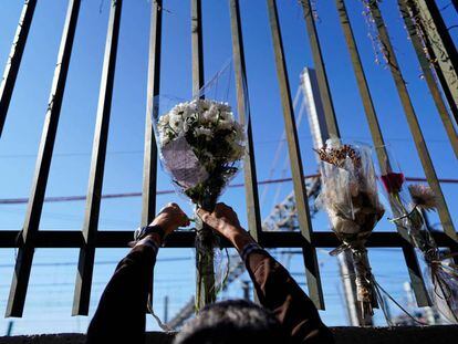 Una persona deja un ramo de flores en una de las vallas cercanas a la estación de Atocha durante el 15 aniversario de los atentados del 11-M, en Madrid.