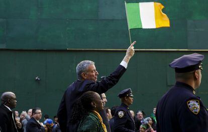 El alcalde de Nueva York Bill de Blasio sostiene una bandera de Irlanda durante el desfile por las calles de Nueva York.