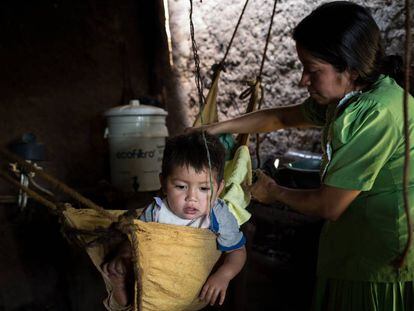 María Josefina lava a Bryan antes de acostarle en la cuna hecha de un saco con cuerdas colgadas de las vigas de madera que constituyen el esqueleto de la casa. Esta madre indígena maya chortíy su hijo viven en la aldea La Ceiba Talquezal, en el departamento de Chiquimula de Guatemala. Este país afrontó entre el 2015 y el 2016 una de las peores sequías registradas en los últimos 25 años, cuyas secuelas aún persisten entre la población del Corredor Seco, también entre los niños.